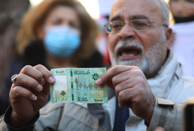 Un homme montre un billet de 100 000 livres libanaises lors d'une manifestation contre l'effondrement du...