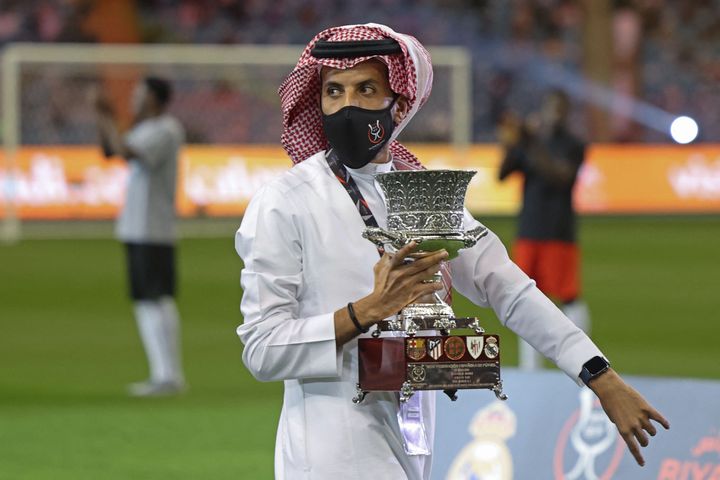 Un miembro de la organización exhibe el trofeo en el estadio Rey Fahd