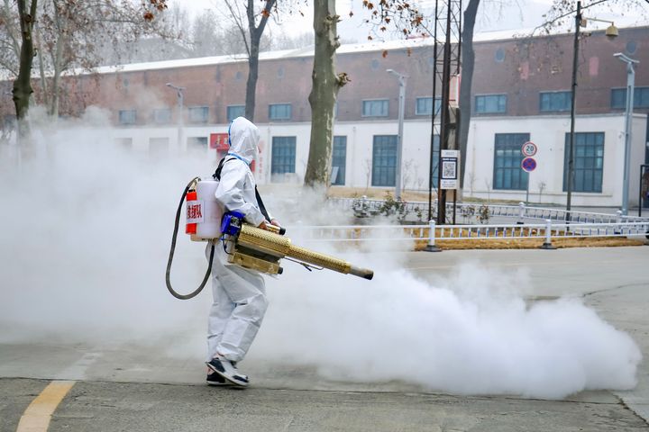 A volunteer wearing personal protective equipment sprays disinfectant at a park on Jan. 11 in Zhengzhou, China.