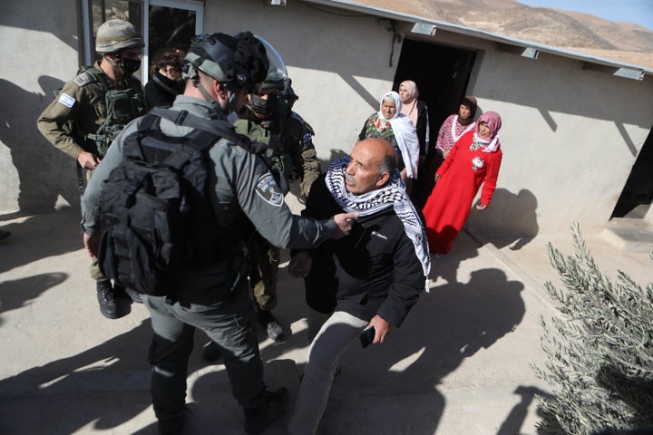Israeli forces confront a Palestinian family whose home they say is "without a license" in Hebron, West Bank, January 12, 2021.