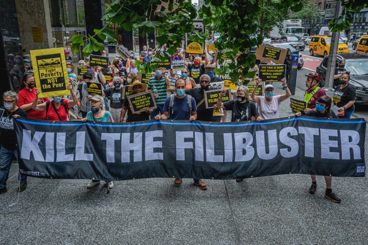 Protesters hold a banner reading "Kill the Filibuster" outside Sen. Chuck Schumer's office in Manhattan,