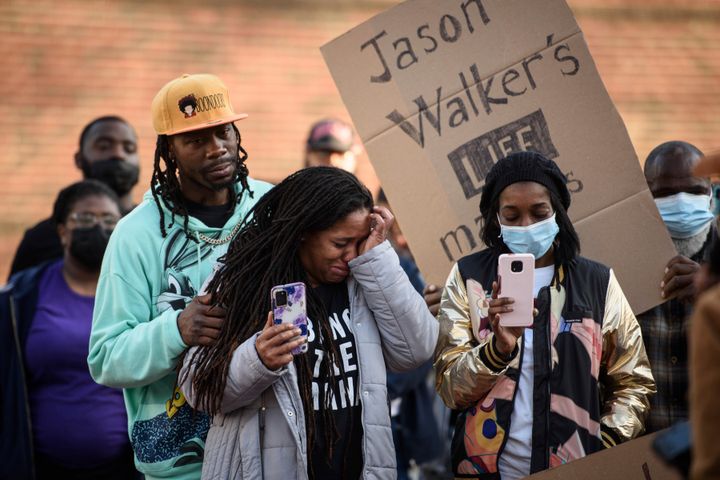 Demonstrators cry during a "Justice for Jason Walker" demonstration in front of the Fayetteville Police Department on Sunday.