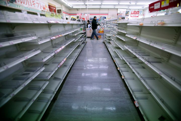 A man shops in a convenience store where shelves on food aisles are left empty in Ofunato, Iwate Prefecture, northern Japan, Tuesday, March 15, 2011, four days after a powerful earthquake-triggered tsunami hit Japan's east coast. (AP Photo/Shizuo Kambayashi)