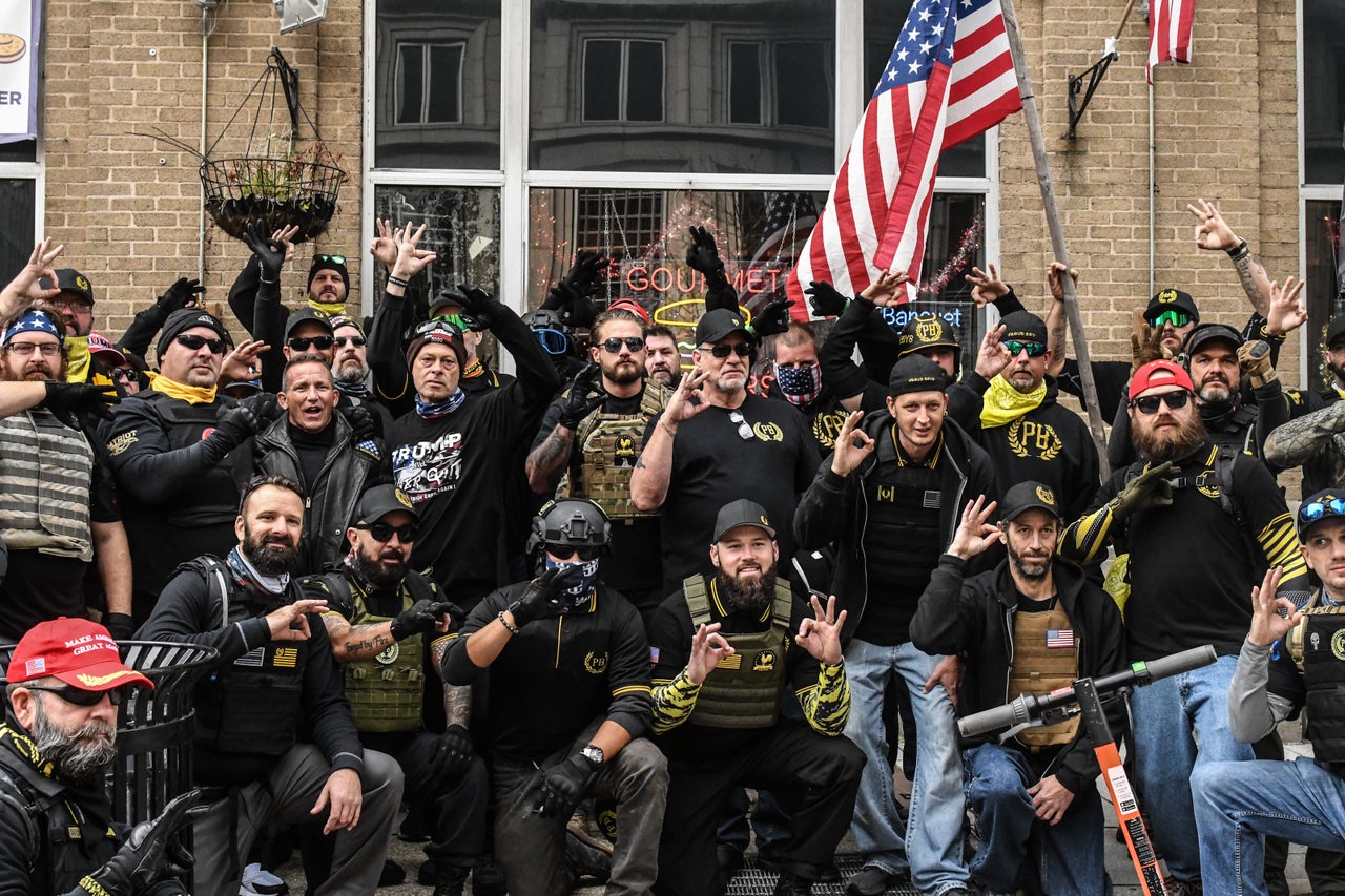 Members of the Proud Boys pose for a photo while flashing a gesture associated with the white power movement outside of Harry's bar during a protest on December 12, 2020, in Washington, D.C. Fischer was among them.