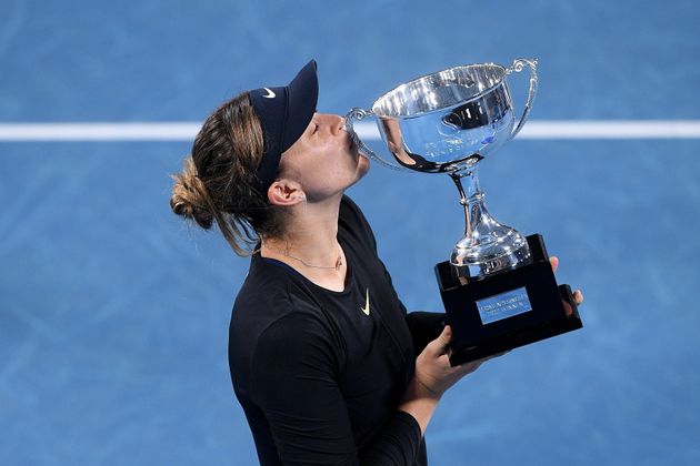 La tenista española Paula Badosa besa el trofeo que le acredita como campeona del torneo internacional...