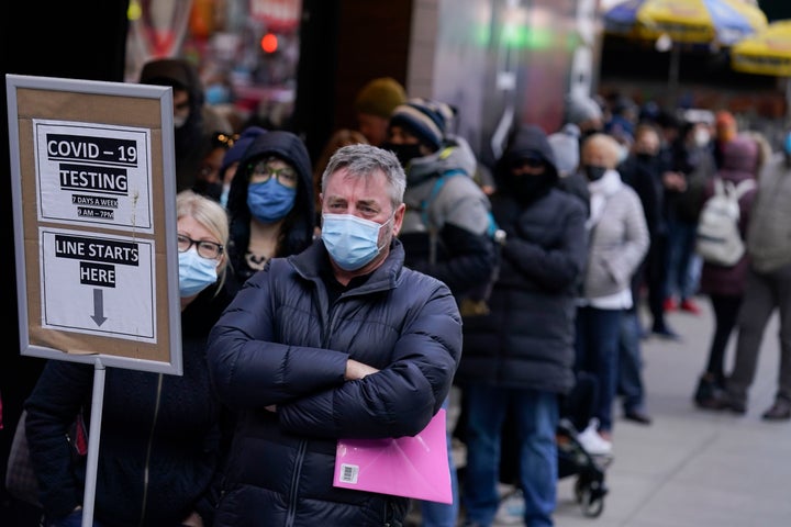 People wait in line at a COVID-19 testing site in Times Square, New York, Monday, Dec. 13, 2021.