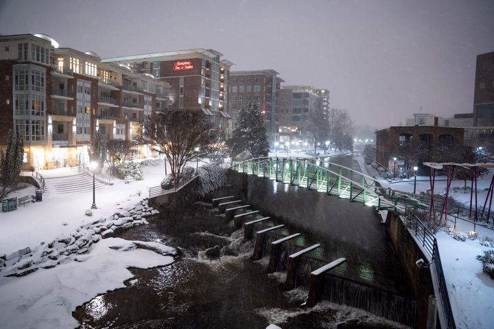 Snow falls along the Reedy River in Greenville, South Carolina on Sunday. Snow, sleet and freezing rain are expected in the area for the remainder of the day.