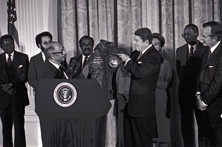 President Ronald Reagan is presented with a flight jacket by Lt. Colonel (Retired) Charles McGee, President of the Tuskegee Airmen Association making Reagan an Honorary Member of the TAI, Washington DC, February 2, 1984. (Photo by Mark Reinstein/Corbis via Getty Images)