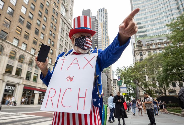 ニューヨークで行われた気候変動への抗議活動で「金持ちに課税を」と書かれたパネルを首から下げる参加者（2021年9月17日）
