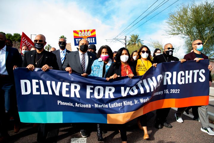 From left, Dr. Warran H Stewart Sr., Martin Luther King III, Yolanda Renee King, Ardrea Waters King and Chanel Poe carry a sign for the Deliver For Voting Rights organization in Phoenix on Saturday, Jan. 15, 2022. (Zac BonDurant//The Arizona Republic via AP)
