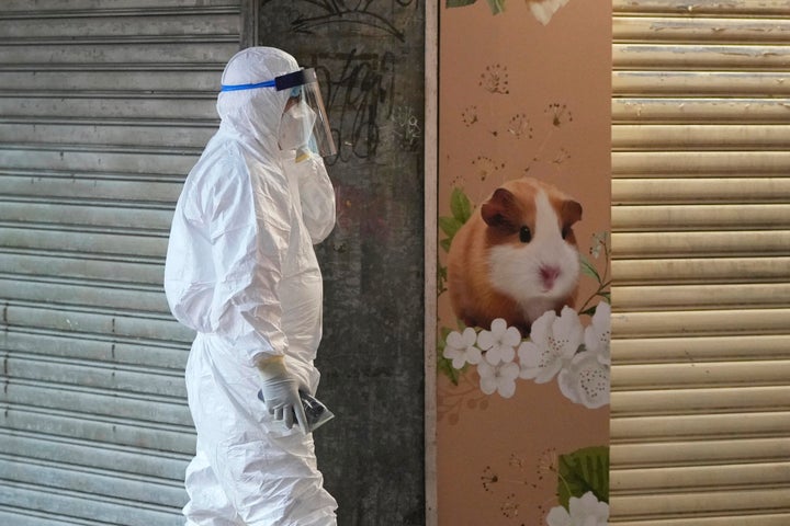 A staffer from the Agriculture, Fisheries and Conservation Department walks past a pet shop which was closed after some pet hamsters tested positive for the coronavirus, in Hong Kong, on Jan. 18, 2022.