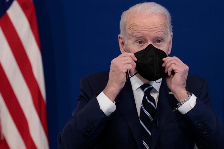 U.S. President Joe Biden holds a mask as he gives remarks on his administration's response to the surge in COVID-19 cases across the country from the South Court Auditorium in the Eisenhower Executive Office Building on January 13, 2022 in Washington, DC.