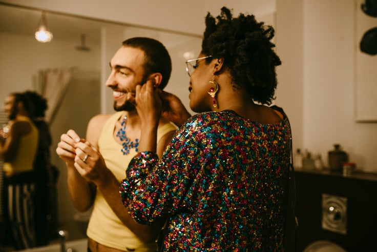 Friends help each other fasten earrings