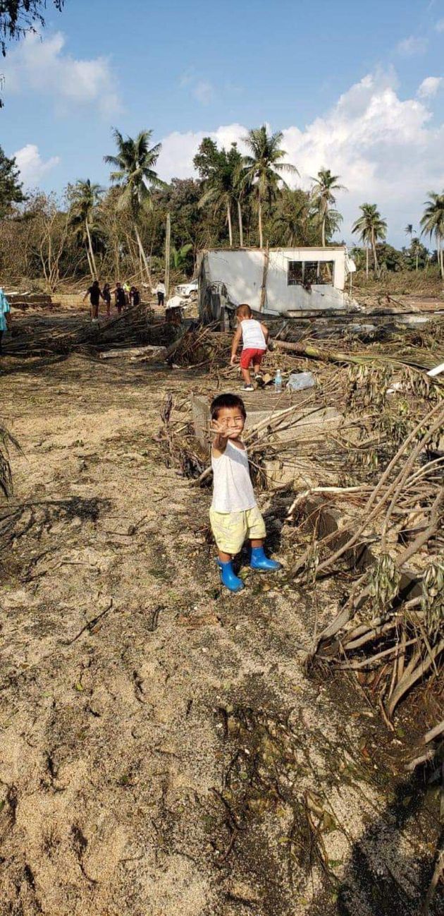 海底火山噴火後のトヌクアロファの写真。なぎ倒された木々と子どもたち（トンガ王国名誉領事館の投稿より）
