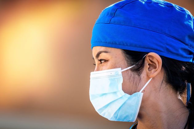 Smiling asian female healthcare worker looking away