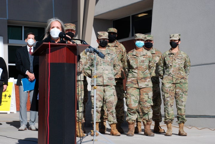 New Mexico Gov. Michelle Lujan Grisham, center, announced efforts to temporarily employ National Guard troops and state bureaucrats as substitute teachers and preschool caregivers, during a news conference at Sante Fe High School in Santa Fe, N.M., on Jan. 19, 2022.