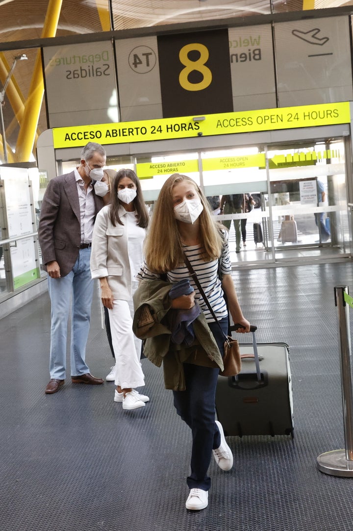 La infanta Sofía se apoya sobre su padre mientras la reina Letizia observa a Leonor entrar en el aeropuerto rumbo a Gales.