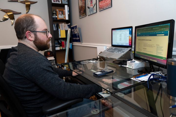 Ethan Miller works on his taxes at home in Silver Spring, Md., Friday, Jan., 21, 2022. Tax filing season starts Monday and people can expect the task to be more cumbersome than usual this year thanks to an overloaded and understaffed IRS workforce and new complications from pandemic-related programs.