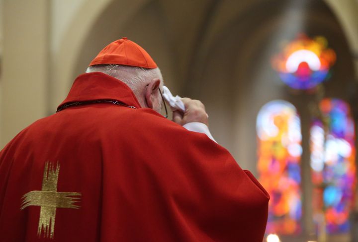 El cardenal alemán Reinhard Marx se seca el sudor durante una misa