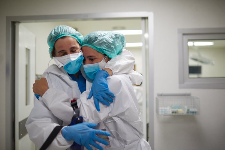 Abrazo de felicidad entre dos sanitarias con EPI.
