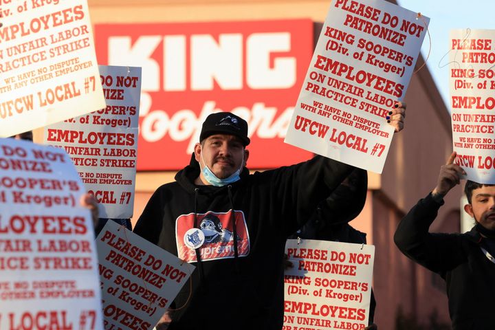 Union members raise signs outside a King Soopers store during a protest on Jan. 12.