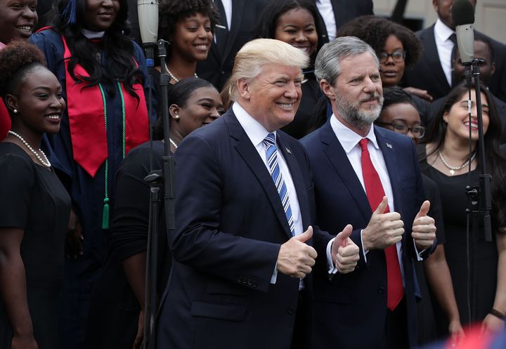 Donald Trump and Jerry Falwell Jr. pose for photos with members of gospel choir Lu Praise during a commencement at Liberty University in May 2017.