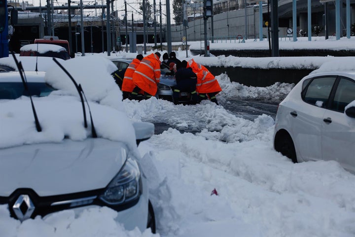 Un grupo de personas tratan de arrancar un coche en Atenas.