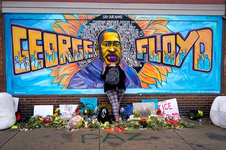 In this Friday, April 23, 2021 file photo, Damarra Atkins pays respect to George Floyd at a mural at George Floyd Square in Minneapolis.