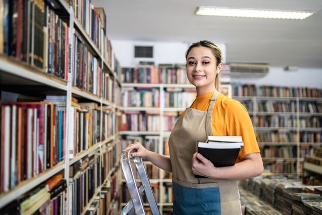 Portrait of a bookseller arranging books in a shelf