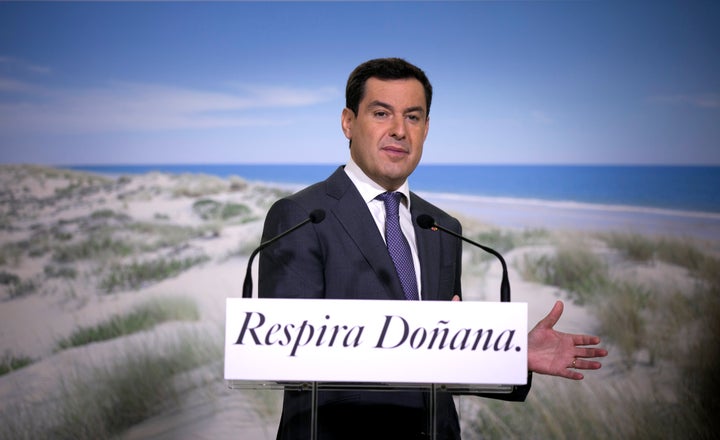 El presidente de la Junta de Andalucía, Juan Manuel Moreno, ante un cartel promocional de Doñana.