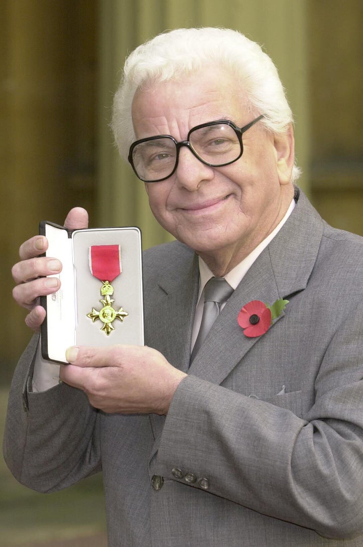 Barry Cryer posing with his OBE medal