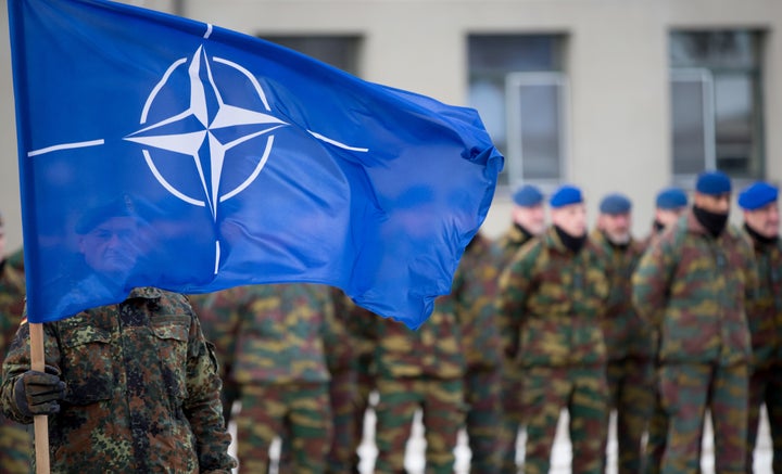 Un soldado alemán sostiene la bandera de la OTAN en su destacamento de Rukla, Lituania, en 2017.