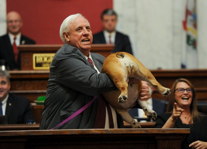 West Virginia Gov. Jim Justice holds up his dog Babydog's rear end as a message to people who've doubted the state as he comes to the end of his State of the State speech in the House chambers, Thursday, Jan. 27, 2022, in Charleston, W.Va. (Chris Dorst/Charleston Gazette-Mail via AP)