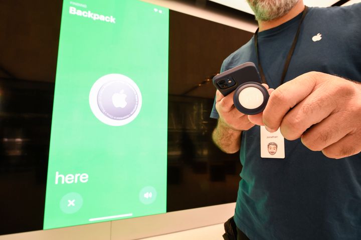 An Apple staff member demonstrates the new Apple AirTag.