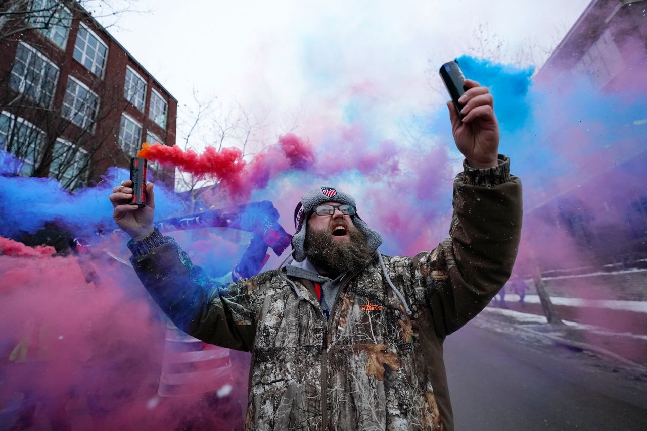 Scott Spencer holds colorful flares on Thursday as he and a group of United States men's national soccer team supporters march ahead of a FIFA World Cup qualifying soccer match against El Salvador in Columbus, Ohio.
