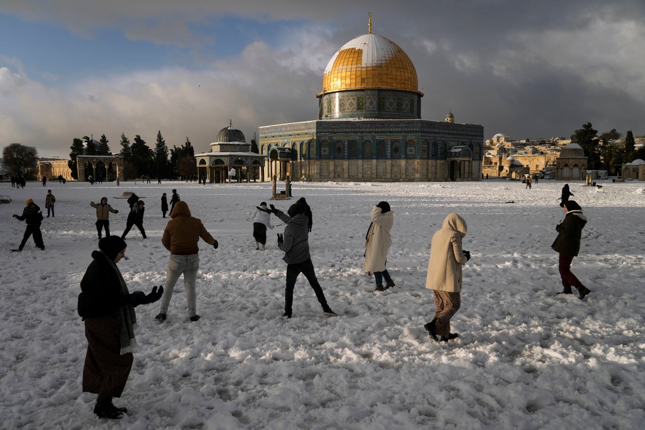 Palestinians enjoy the snow next to the Dome of the Rock Mosque in the Al Aqsa Mosque compound in Jerusalem Old city on Thursday. A rare snowfall hit parts of Israel and the West Bank, closing schools and businesses.
