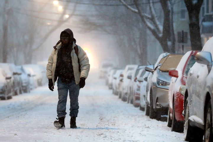 A man walks in the snow covered street in Boston.