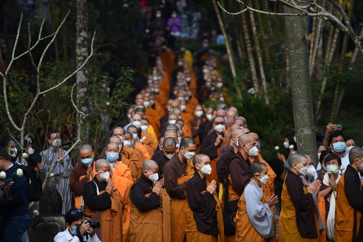 Buddhist monks walk and pray during the procession to a cremation ground for Vietnamese monk Thich Nhat Hanh at Tu Hieu pagoda in Hue province on January 29, 2022 