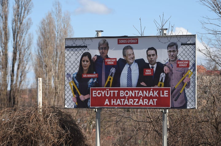 This picture taken on March 12, 2018, nearby Pecs, Hungary, shows a billboard featuring Hungarian-American billionaire and philanthropist George Soros (center) beside opposition candidates Bernadett Szel (left) of the green liberal LMP party, Ferenc Gyurcsany (second from left) of the Democratic Coalition, Gabor Vona (second from right) of Jobbik and Gergely Karacsony of the Dialogue for Hungary party. The text reads: "Together they would take down the fence."