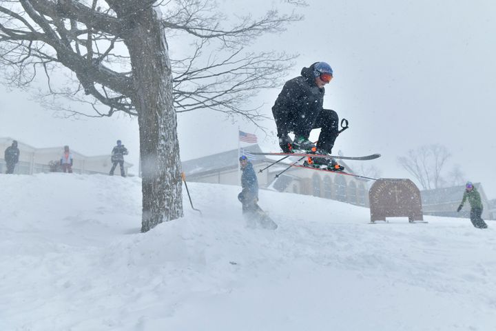 Zack Andersen of Somerville skis off a jump built on the lawn of Dormition of the Virgin Mary Greek Orthodox Church, Saturday, Jan. 29, 2022, in Somervillle, Mass. (AP Photo/Josh Reynolds)