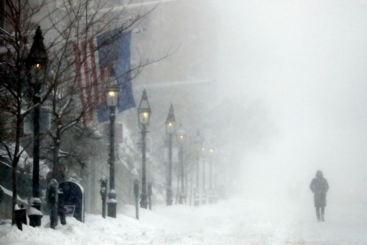 A person walks on Beacon Street in heavy snow, Saturday, Jan. 29, 2022, in Boston. (AP Photo/Michael Dwyer)