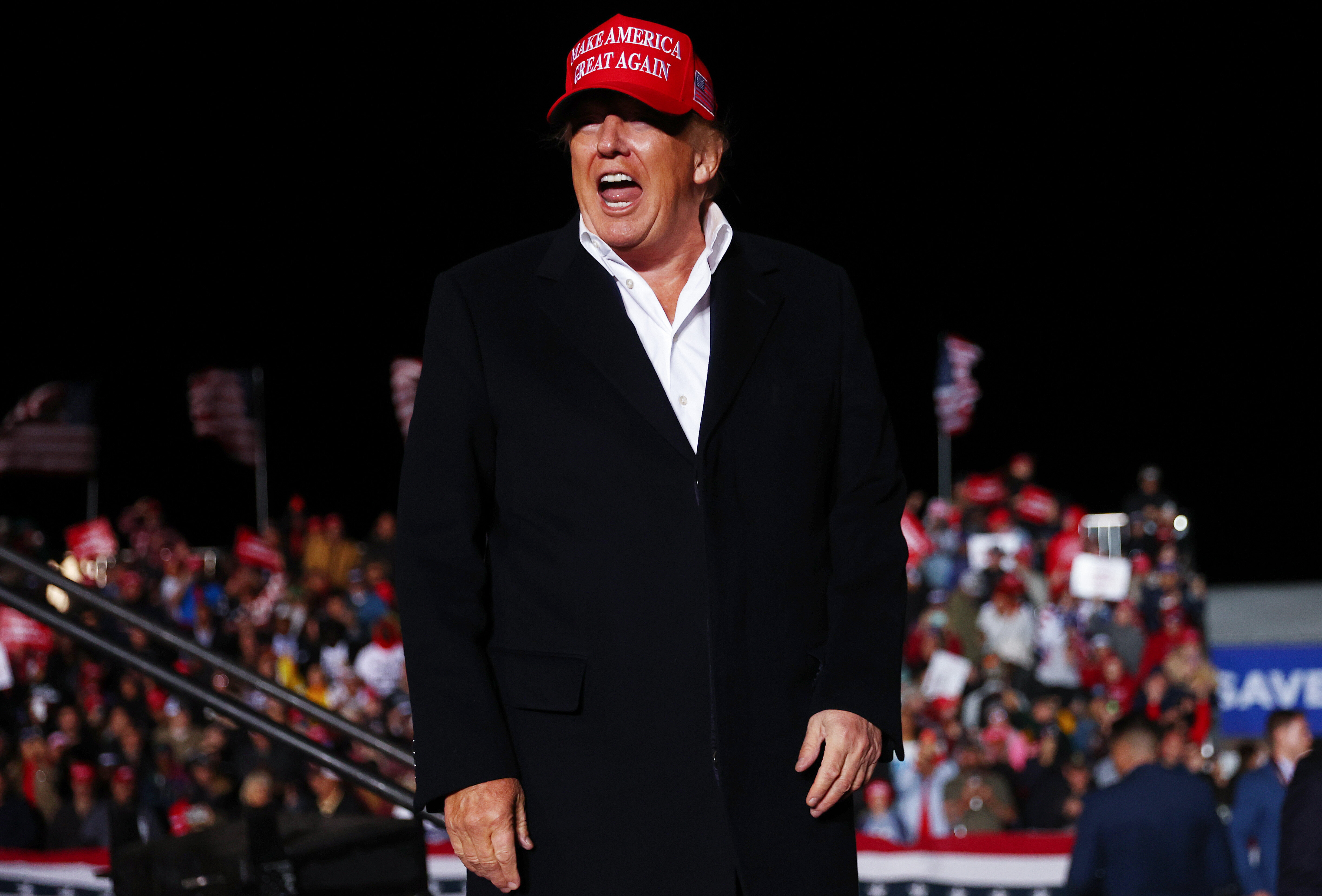 Former President Donald Trump wears red ''Make America Great Again'' hat at a rally.