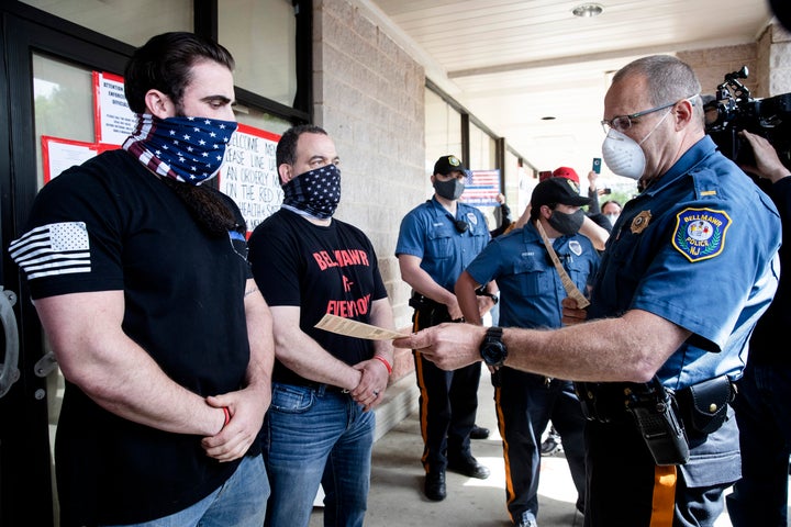 A police officer issues Atilis co-owners Smith, left, and Frank Trumbetti, center, summons in 2020 after they repeatedly defied the governor's order to remain closed during the COVID-19 pandemic.