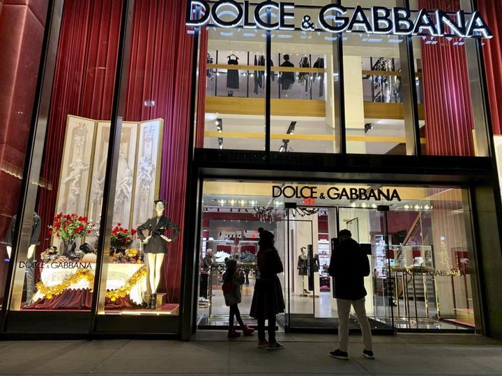 FILE - People stand outside the Dolce & Gabbana store on Fifth Avenue on Nov. 21, 2021 in New York.