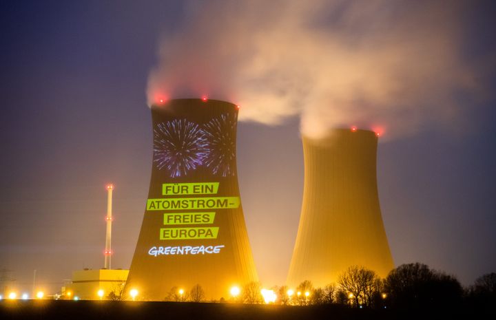 30 Δεκεμβρίου 2021, Κάτω Σαξονία. Σύνθημα της Greenpeace προβάλεται σε ένα από τα τεράστια φουγάρα του εργοστασίου παραγωγής ηλεκτρικής ενέργειας από πυρηνική ενέργεια στο Grohnde. Photo: Julian Stratenschulte/dpa (Photo by Julian Stratenschulte/picture alliance via Getty Images)