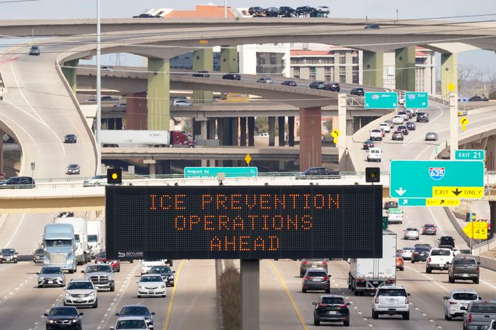 A street sign warns drivers of ice prevention operations on highways ahead of winter weather in Dallas, on Feb. 1, 2022. 
