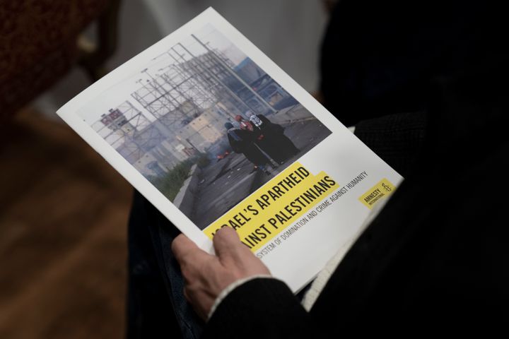 A journalist holds a copy of Amnesty International's report "Israel's Apartheid Against Palestinians," at a press conference on the release of the 278-page report compiled over a period of four years, in Jerusalem, Tuesday, Feb. 1, 2022. The London-based rights group said Tuesday that Israel has maintained "a system of oppression and domination" over the Palestinians going all the way back to its establishment in 1948, one that meets the international definition of apartheid.