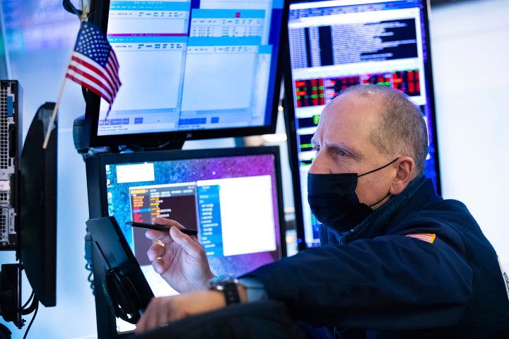 In this photo provided by the New York Stock Exchange, trader Michael Urkonis works on the floor, Thursday, Feb. 3, 2022. Stocks fell on Wall Street Thursday as Facebook parent company Meta plunged 26%, erasing more than $220 billion in market value, the largest drop in history. (Allie Joseph/New York Stock Exchange via AP)