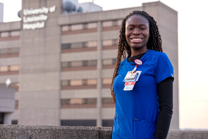 Faith Akinmade, an ICU nurse at the University of Louisville Hospital in Louisville, who is originally from Nigeria, poses for a photo in front of the hospital. After completing college in the United States, Akinmade has been working at the hospital, but her work permit is set to expire in March and she said she needs it renewed, or her green card approved, to stay on the job.