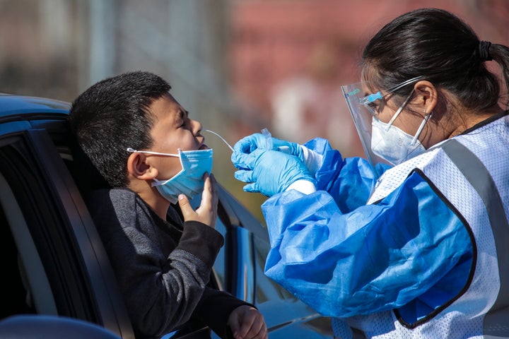 Bruce Mendoza, 6, gets a COVID-19 test at a testing facility in Boyle Heights, Los Angeles.